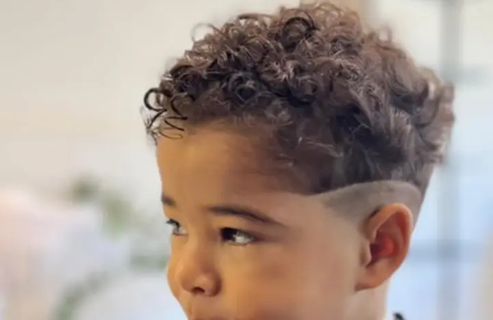 Criança sorrindo após o corte de cabelo infantil na Espaço Muniz